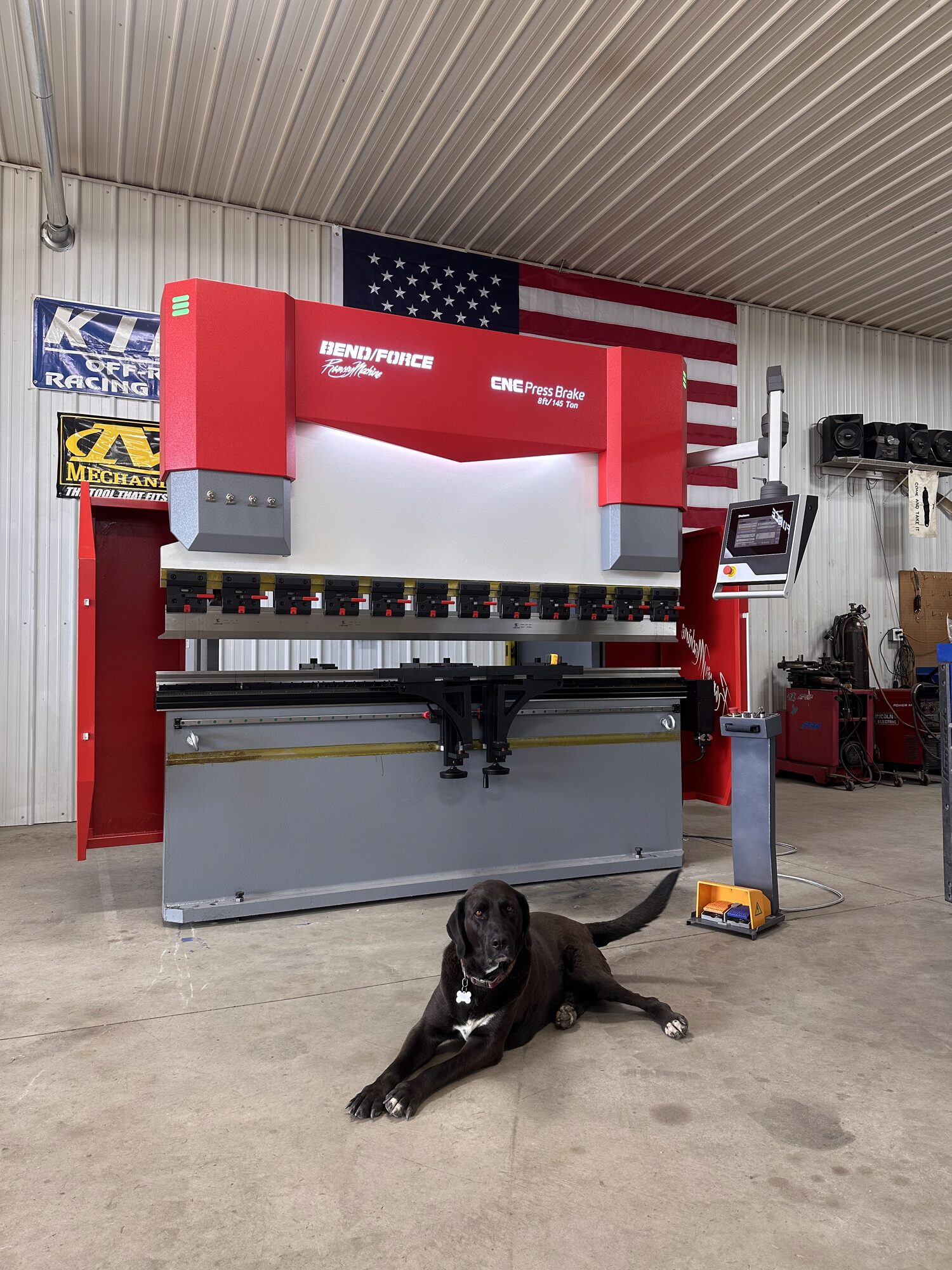 ArcWest CNC press brake on the shop floor with the shop dog standing by
