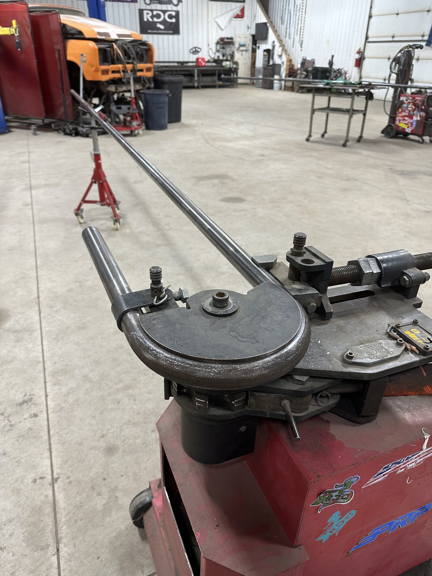 ArcWest hydraulic tube bender on the shop floor with a long bent tube extending out