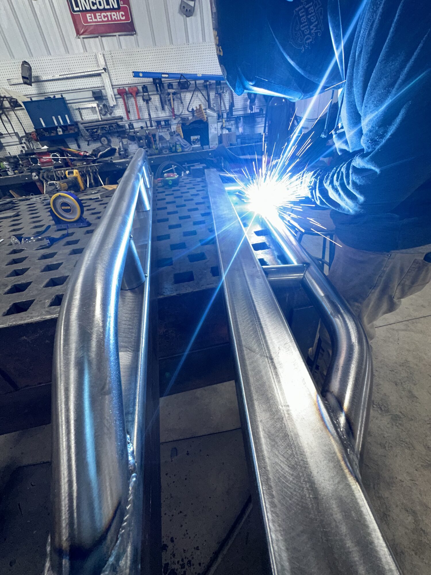 ArcWest precision TIG welding on a custom tube assembly under a Lincoln Electric sign